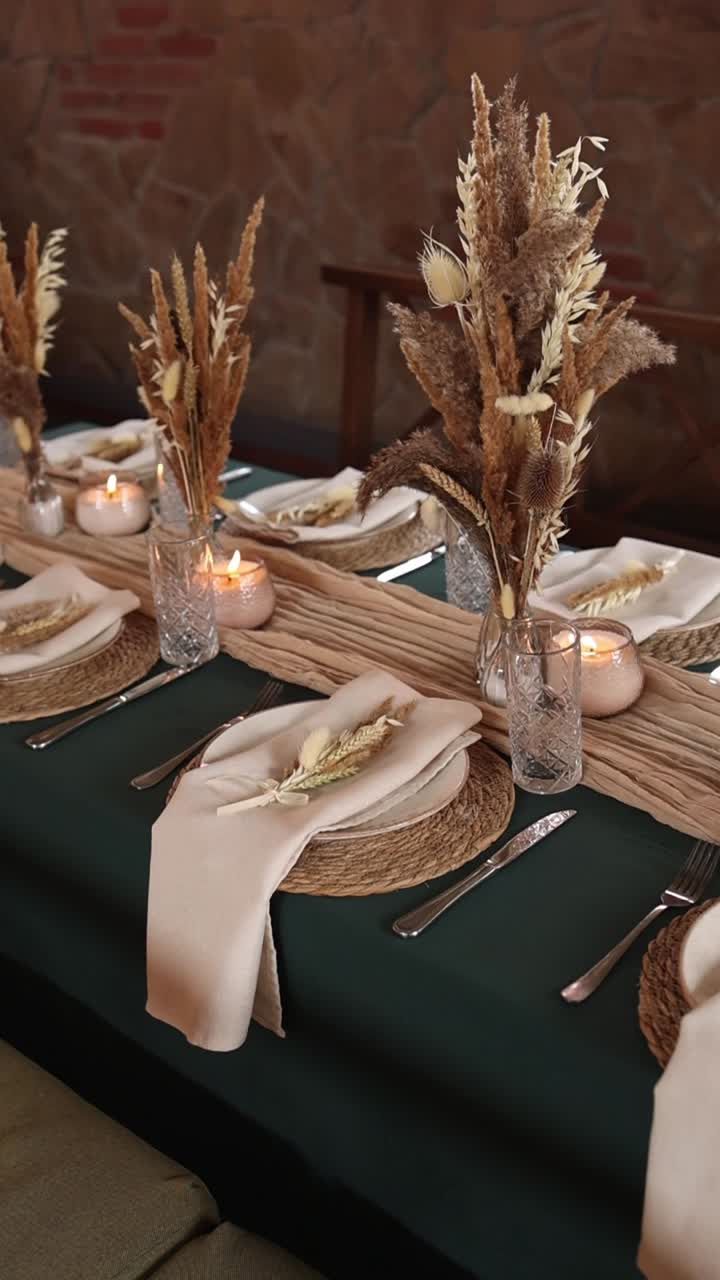 Elegante apparecchiatura di una tavola da pranzo con fiori secchi e candele