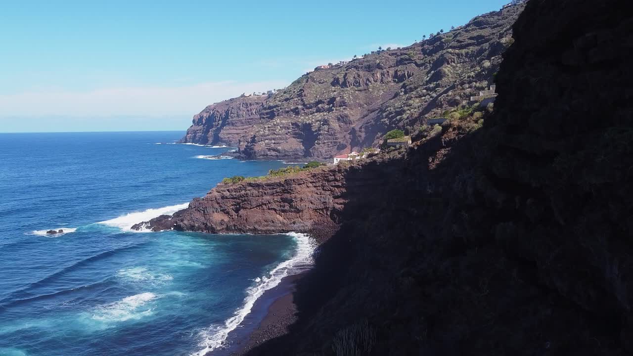 Hermoso paisaje costero, olas azules del océano con palmeras verdes en un acantilado alto en Tenerife en un día soleado, Aéreo