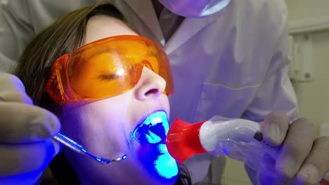dentista examinando a una paciente femenina con una herramienta dental