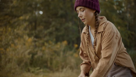 female explorer removing backpack in forest