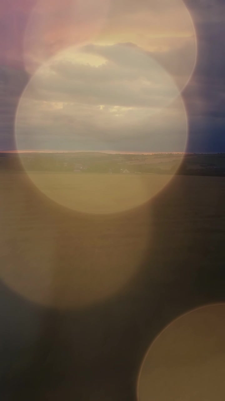 Vídeo vertical: Horizonte e nuvens de tempestade permanecendo enquanto um bokeh flutuante revela uma linha fina e brilhante