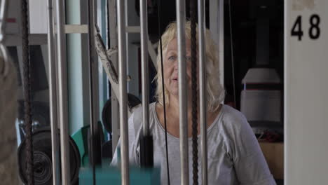 mujer mayor bajando el peso en el ejercitador