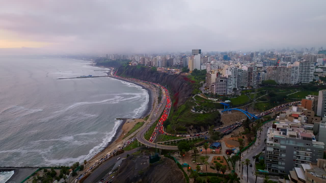 Tebing pantai dan cakrawala kota saat matahari terbenam mendung di Lima, Peru, gambaran umum panorama udara.