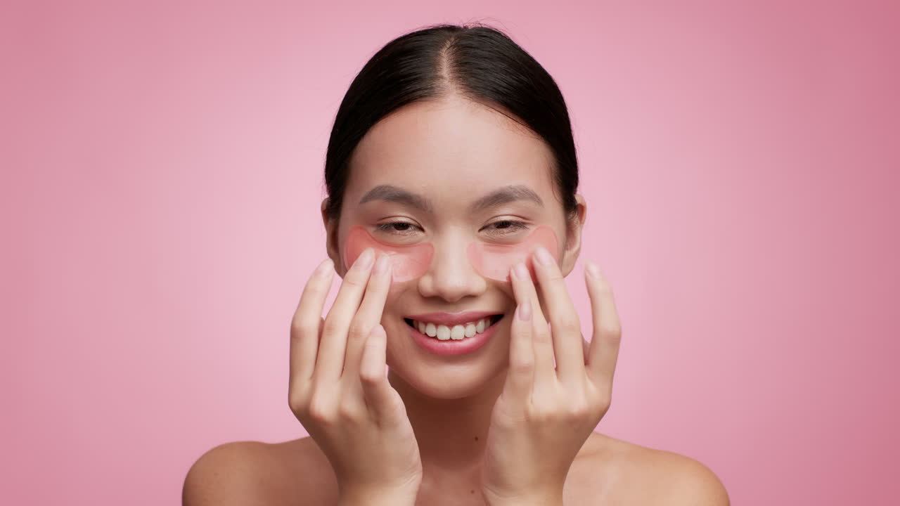Young woman applying under-eye patches for skincare