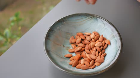 recogiendo almendras a mano de un cuenco
