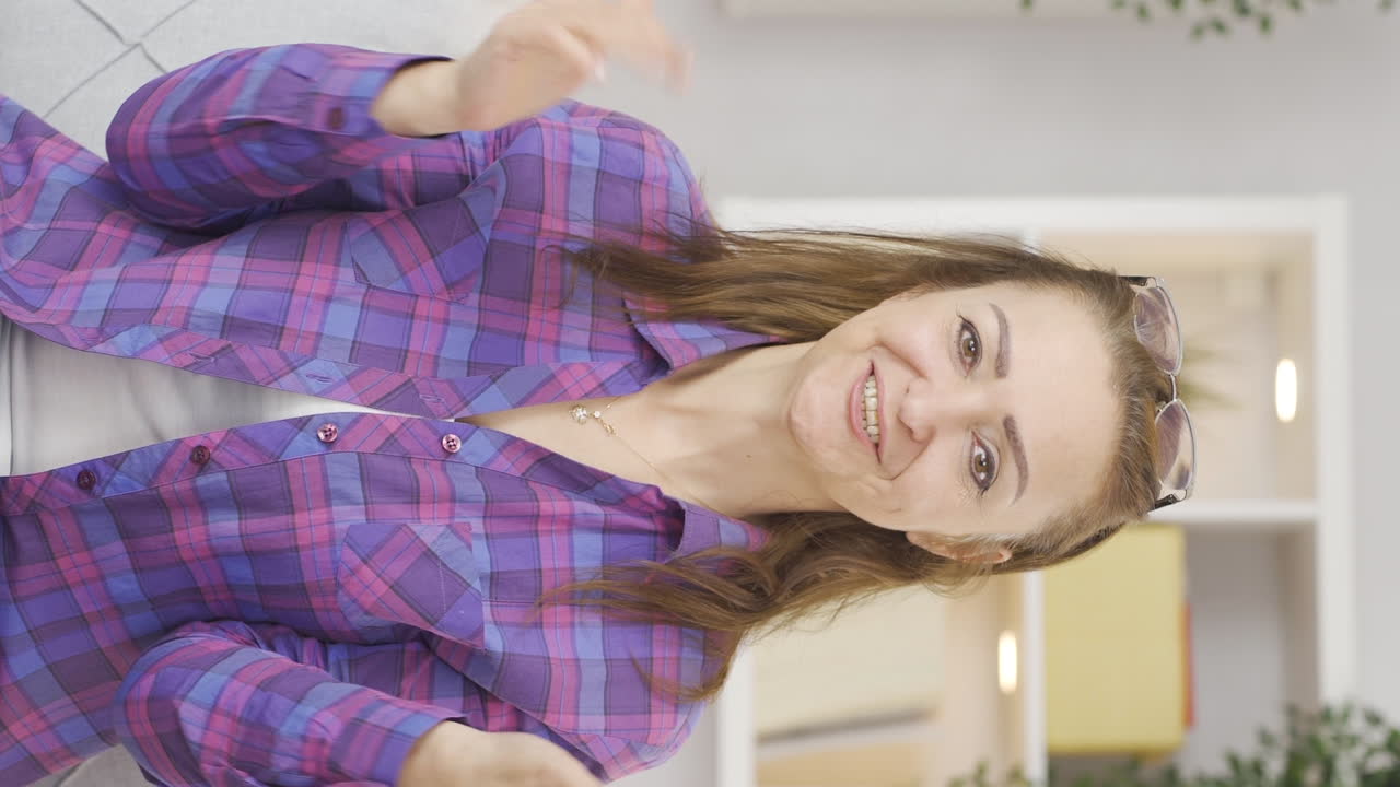 video vertical de una mujer dando saludo y aplausos a la cámara.