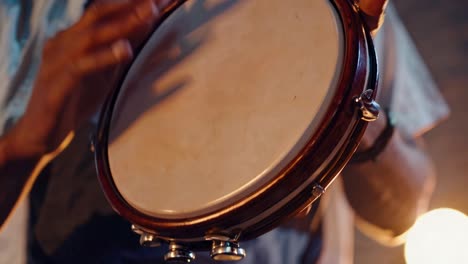 close-up video shot of hands playing a tambourine, capturing rhythmic motion and musical energy