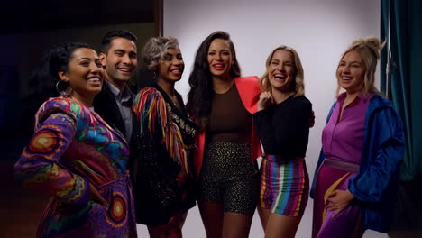 a diverse group of friends laughing and smiling together at a social event