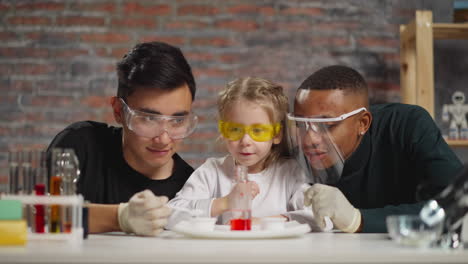 girl nods looking at asian lab assistant adding reagent