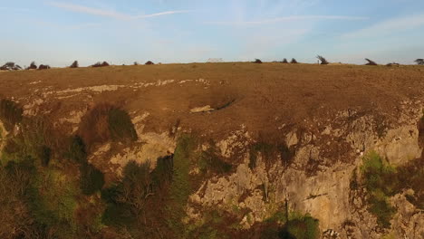 a reveal shot over a hill looking at the coastline in the english lake district during sunset