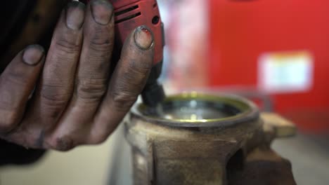 A-mechanic-with-extremely-dirty-hands-is-cleaning-a-housing-with-a-drill-to-make-ready-for-a-new-bush