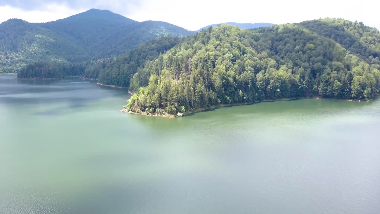 루마니아의 발레아 드라가눌루이 산맥을 둘러싼 물의 오버헤드 공중 드론 샷