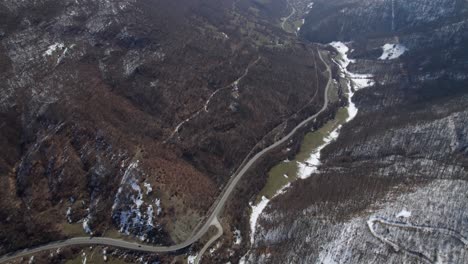 Drone-footage-of-snow-capped-mountains-and-a-road-in-between-in-a-remote-part-of-Romania