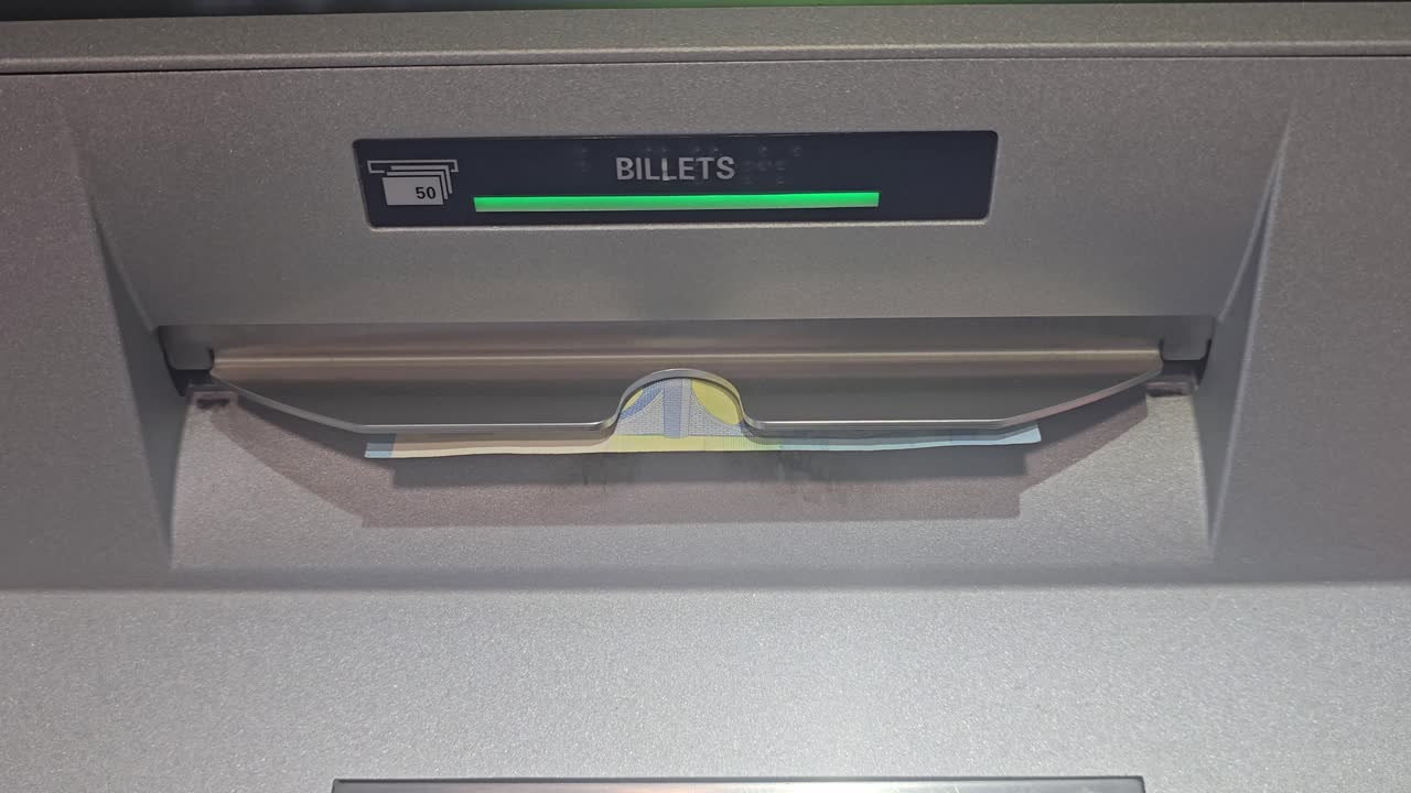 Closeup of ATM cash dispenser slot showing 20 euro note being withdrawn, banking concept