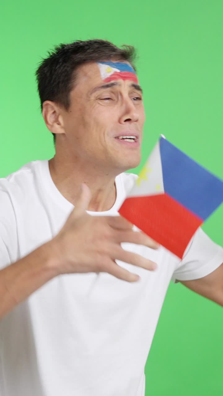 Nervous man cheering for Philippines during a match looking away
