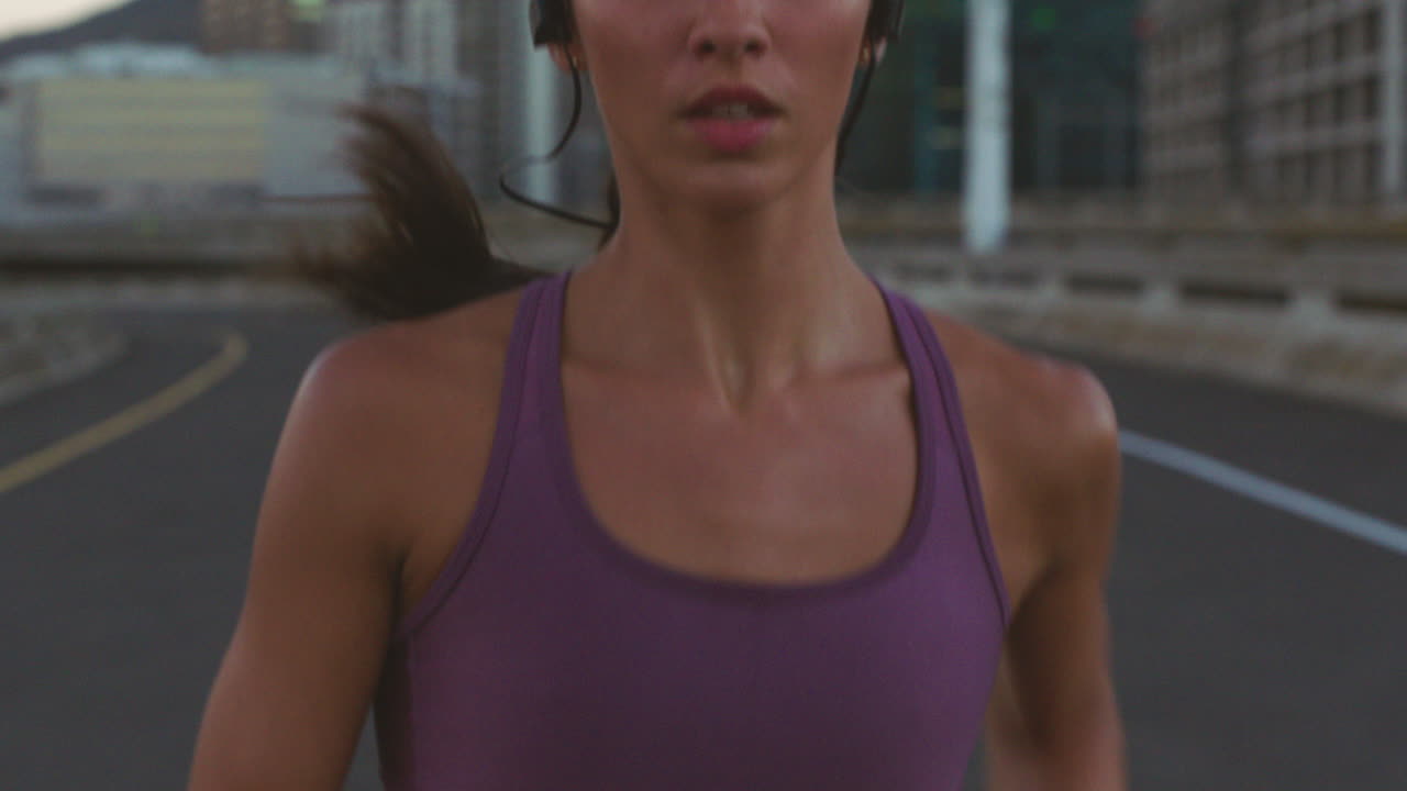 mujer corriendo por la ciudad al anochecer