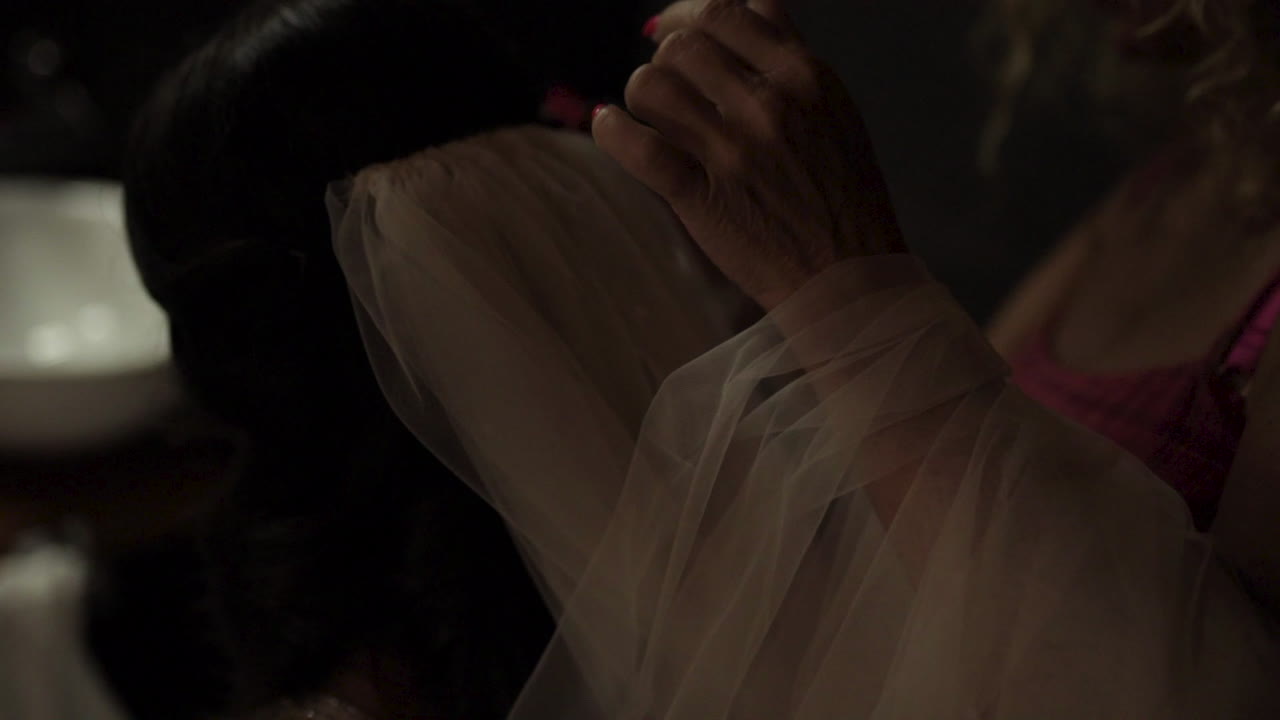Gimbal shot of woman hands adjusting the brides veil. Back view, close up