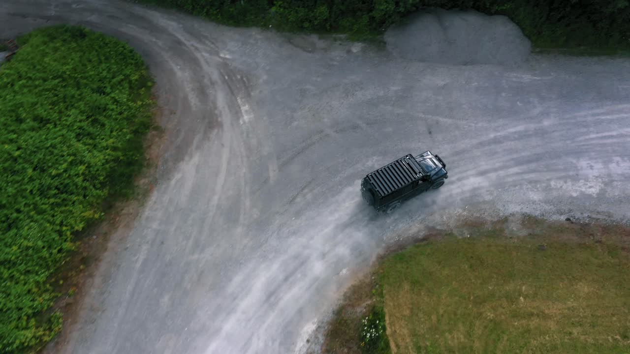 오버헤드 시네마틱 공중 드론 카메라 영상 녹색 들판으로 둘러싸인 시골 풍경에서 지프 운전을 할 수 있습니다.