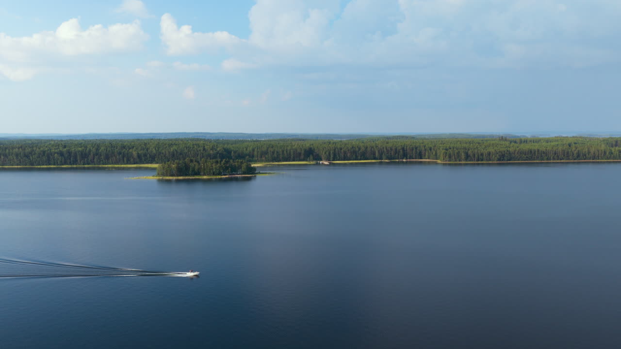 Aerial tracking shot of a motorboat driving on lake Saimaa, summer in Finland