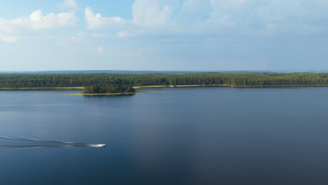 aerial tracking shot of a motorboat driving on lake saimaa, summer in finland