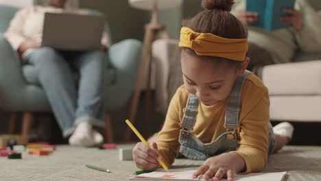 cute african-american girl drawing at home