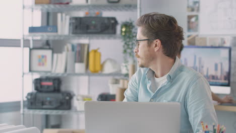 arquitectos masculinos y femeninos en la oficina trabajando en escritorios en computadoras uniéndose para reunirse juntos