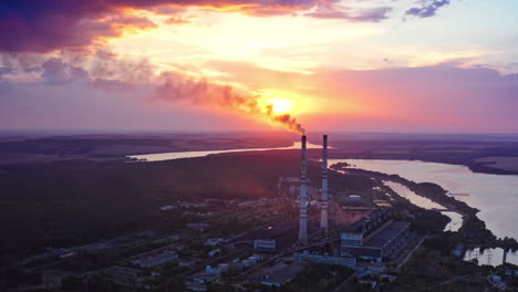 pipes with chemical smoke of industrial plant. panoramic view of factory surrounded by beautiful nature in the evening. air pollution. aerial view.