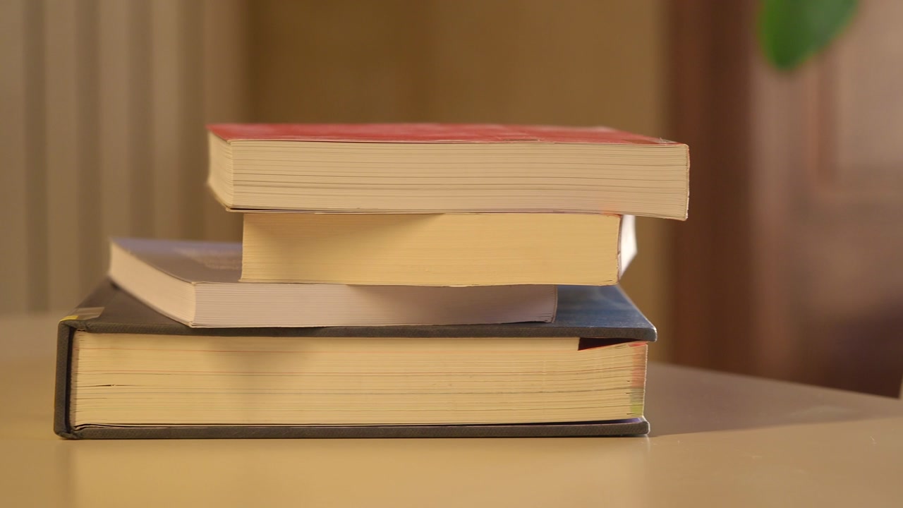 Close Up of Stacked Books on a Table with a Slow Zoom Out