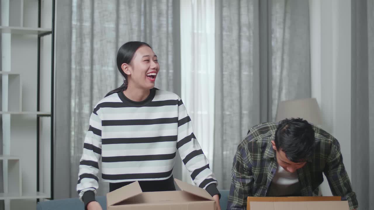 행복한 커플이 이사하고 있습니다.