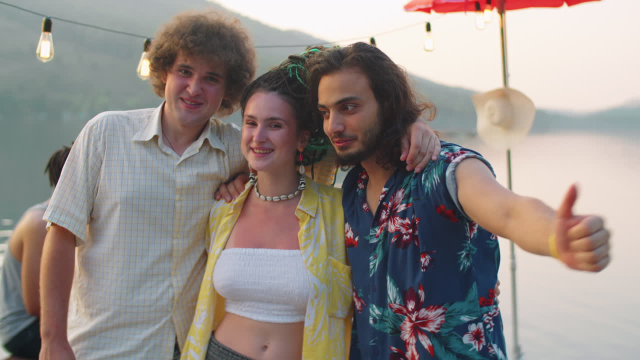 호수 파티에서 함께 포즈를 취하는 웃는 친구들