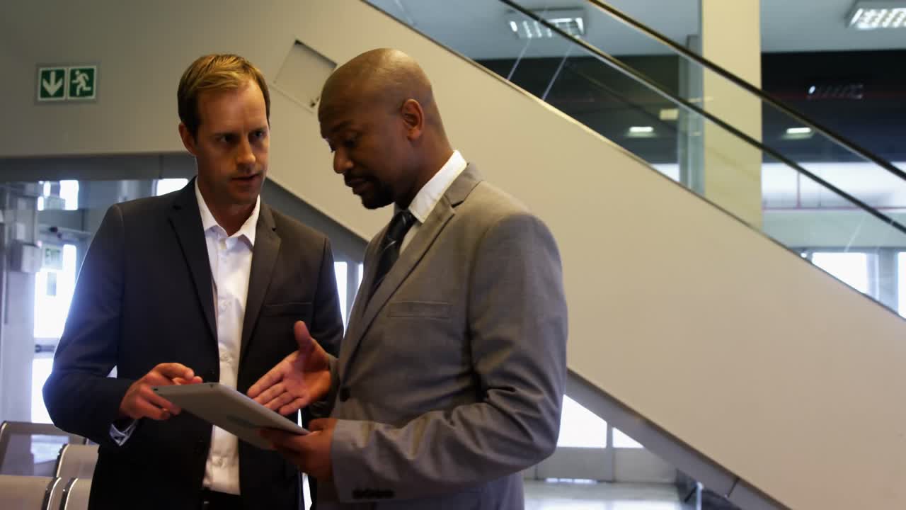 Business people discussing over digital tablet