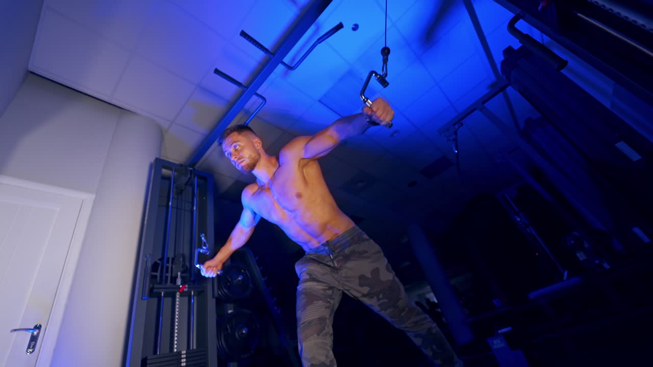 Athlete with strong body doing work out pushing up excercise in gym. View from the bottom.