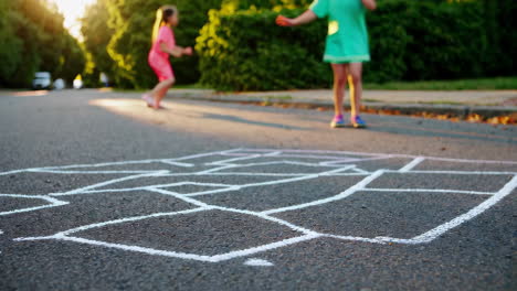 children playing hopscotch outdoors