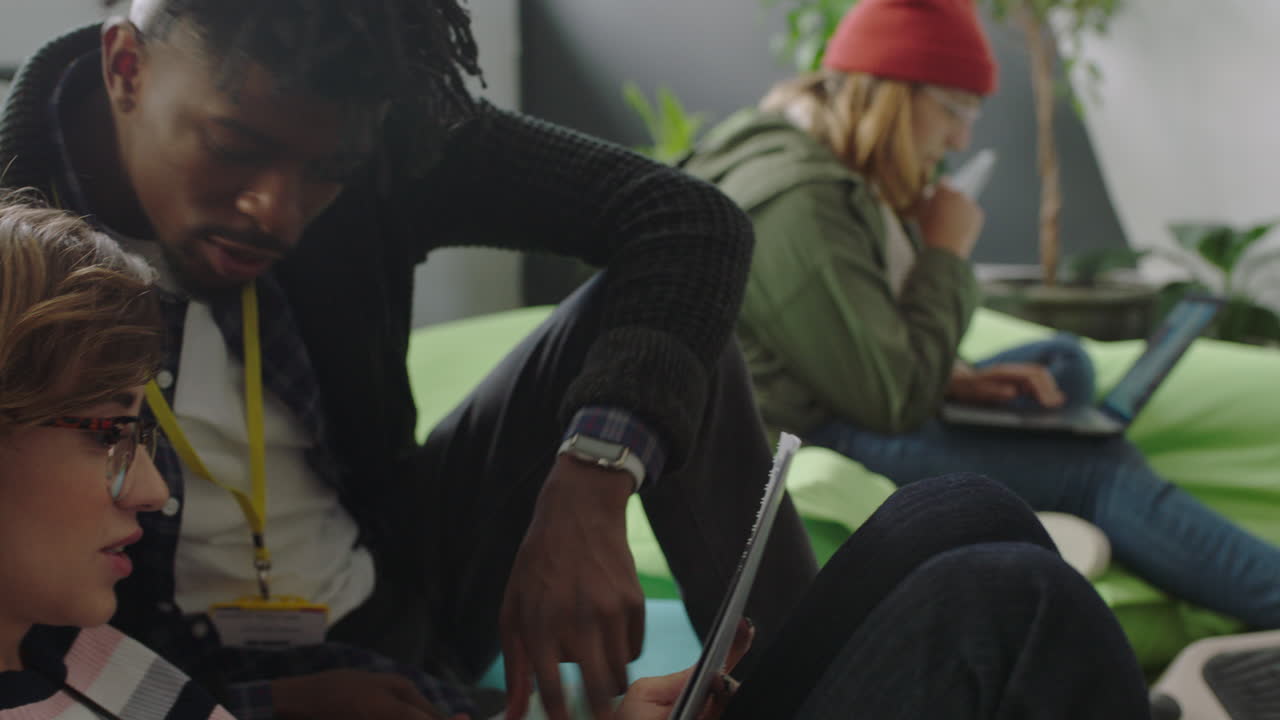 젊은 비즈니스 학생 그룹이 함께 공부하고 프로젝트를 진행하고 브레인스토밍 동료들이 다채로운 다민족 사무실에서 아이디어를 공유합니다.