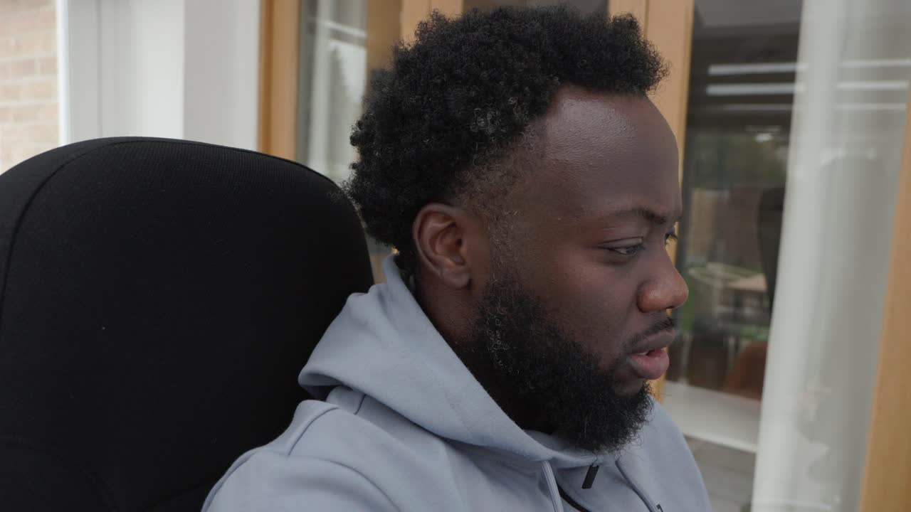Black Male Concentrating On Task In Home Office