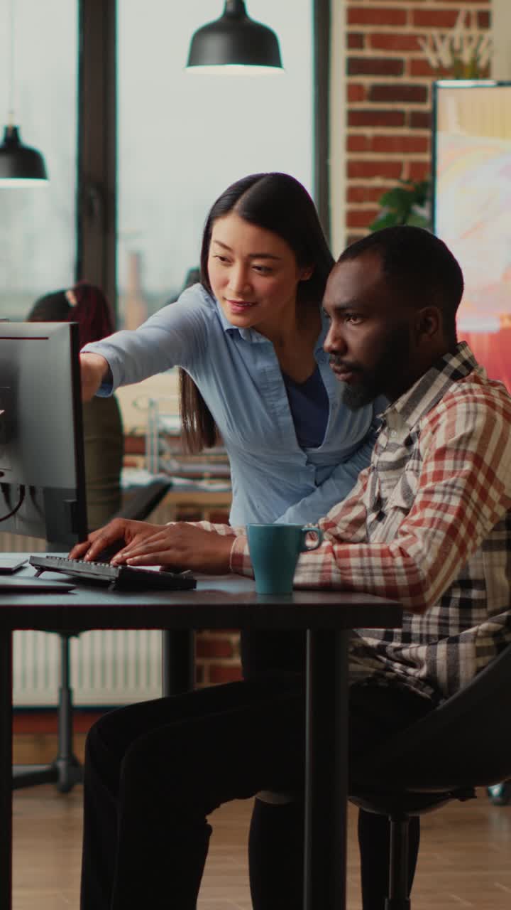 Vertical video: Diverse engineers working on turbine component with modern electronics