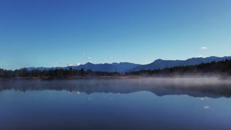 lake mist with mountains and forest enid british columbia canada