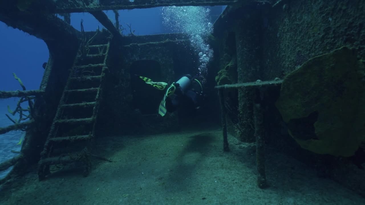 An experienced scuba diver prepares to enter the main superstructure of the ARM General Felipe Xicoténcatl (C-53) wreck off the coast of Cozumel