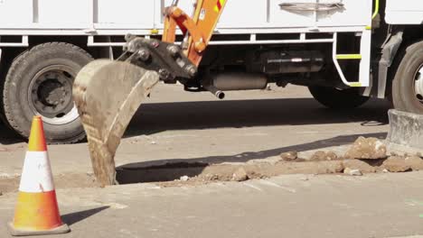 excavator shovel excavating earthworks in road trench