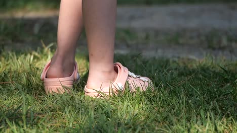 A close up shot of legs and crocs on grass