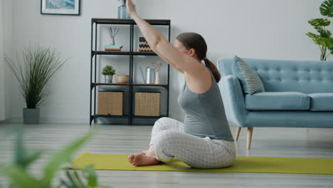mujer embarazada haciendo yoga en casa