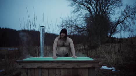 Norwegian-Guy-With-DIY-Wooden-Hot-Tub-In-Outdoor-Nature-Landscape