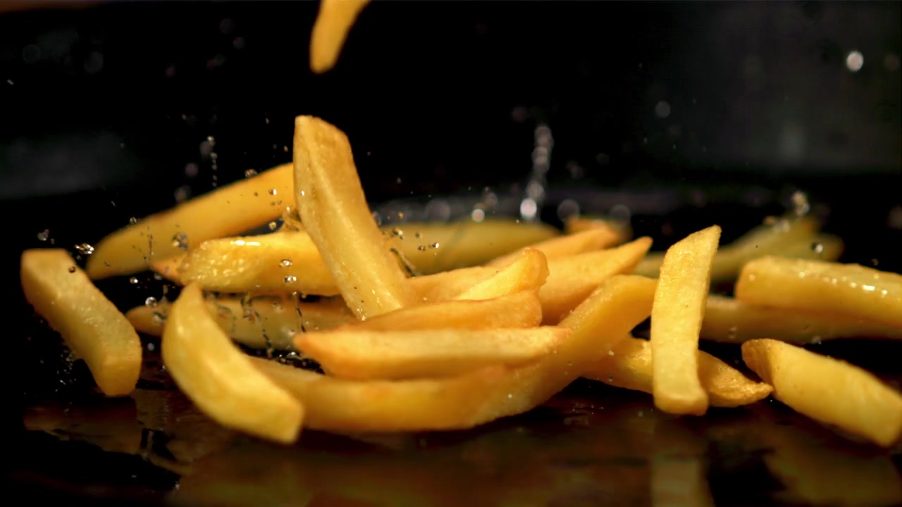 Golden French Fries Falling and Splashing in Slow Motion