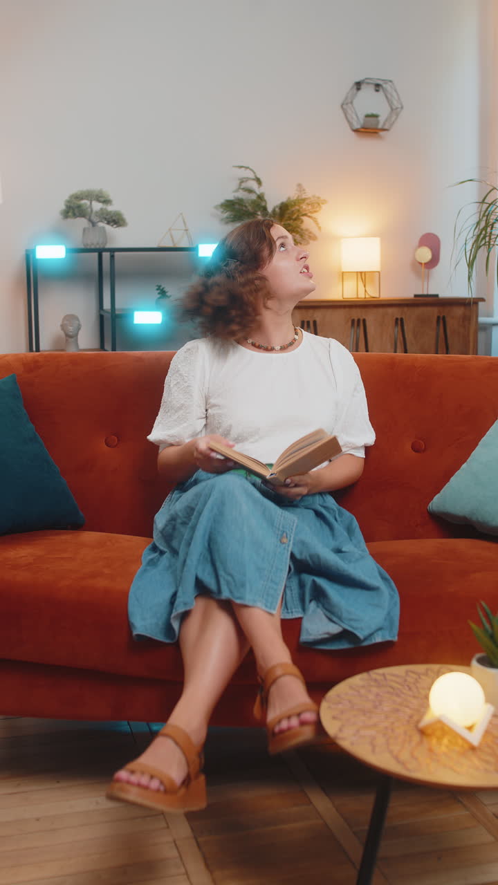 mujer joven irritada leyendo un libro cubre las orejas con almohadas molestado por el ruido fuerte sentado en el sofá