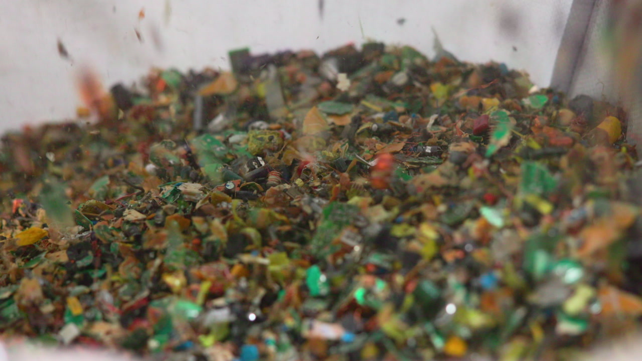 Closeup Of Colorful Plastic Fragments Grinding Inside Industrial Crusher And Conveyor, Mixed Polymers And Tiny . Media