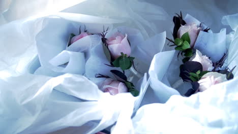 Pink-Roses-In-Crumpled-Paper-Cloth-On-The-Table-In-A-Wedding-Reception