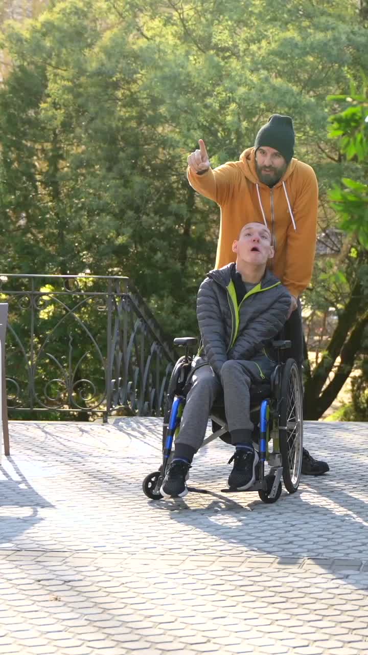 Man in Wheelchair with Caregiver Outdoors
