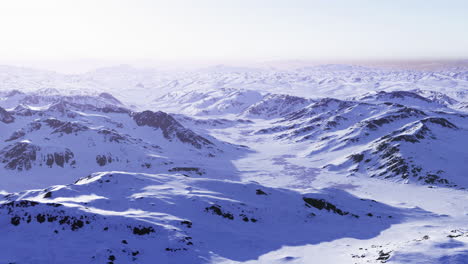 snow covered mountain landscape with vast valleys under a clear sky