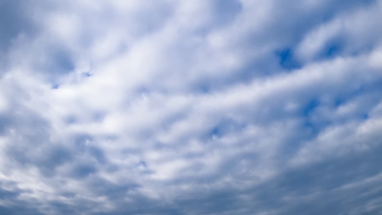 Cloudscape spreading by the horizon at daytime. Low angle view on the overcast sky. Timelapse.