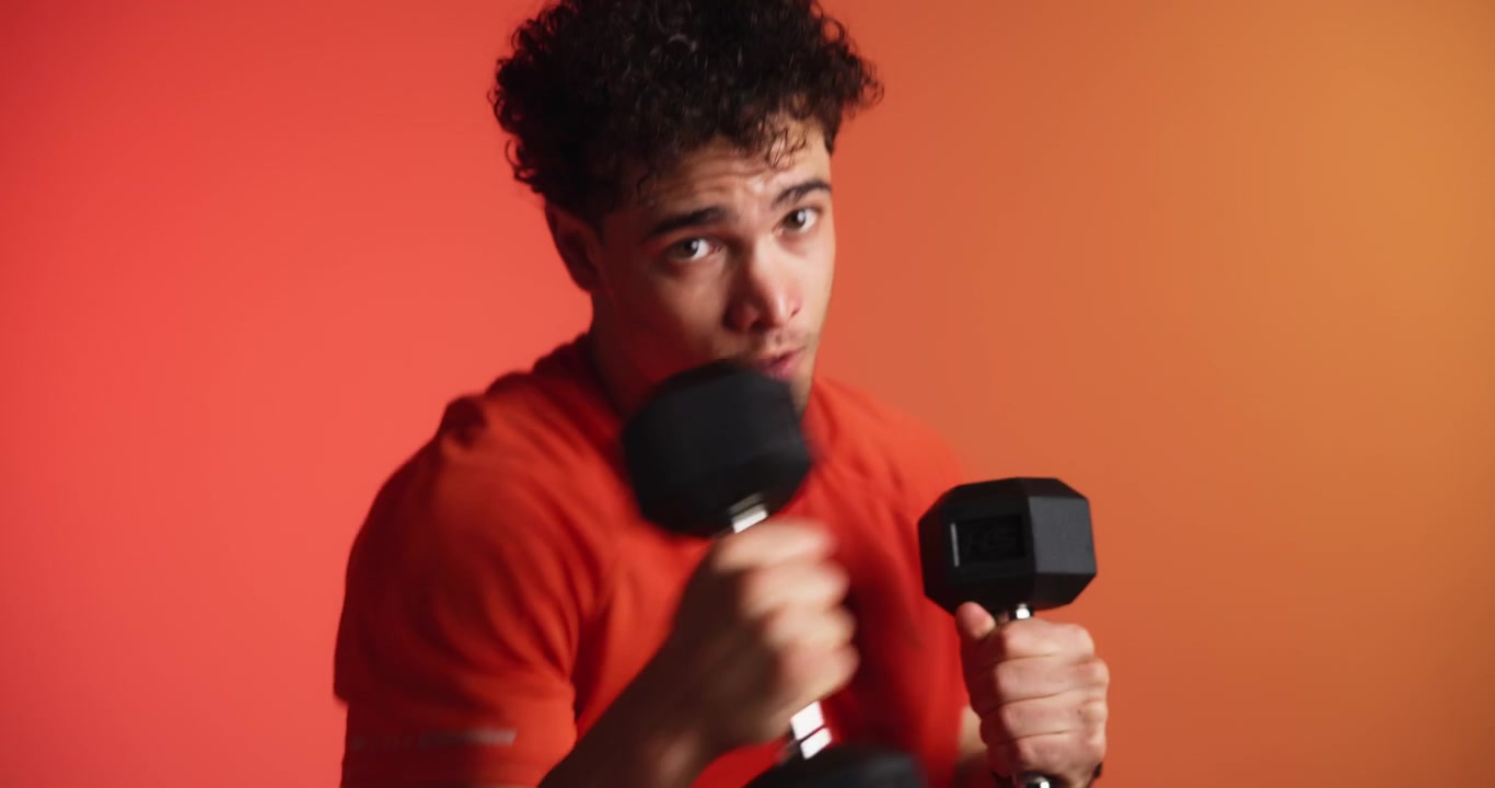 Young Man Performing Shadow Boxing Exercises with Dumbbells